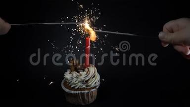 生日会盛宴庆祝理念.. 一个黑蜡烛的纸杯蛋糕。 烟火。 火花在燃烧。 慢动作